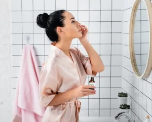 Chica frente al espejo en rutina de skincare - thiamidol retinol